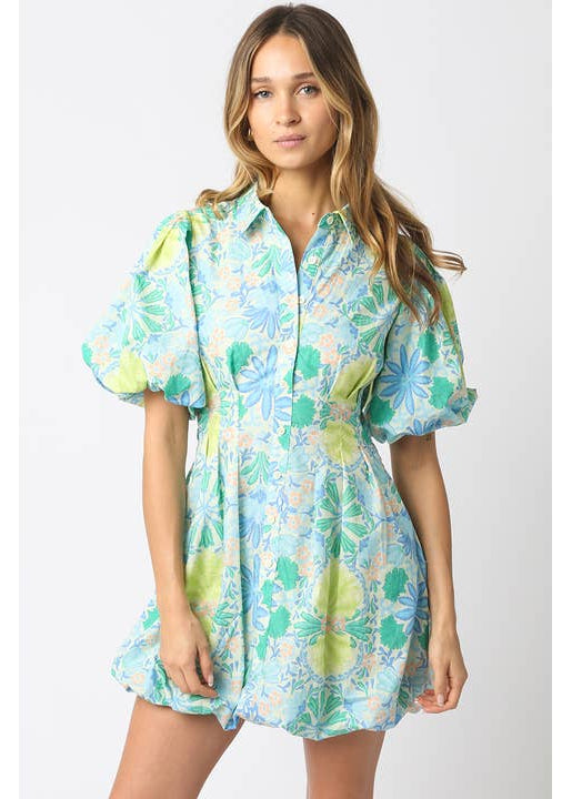 Woman wearing a floral dress with puff sleeves on a white background